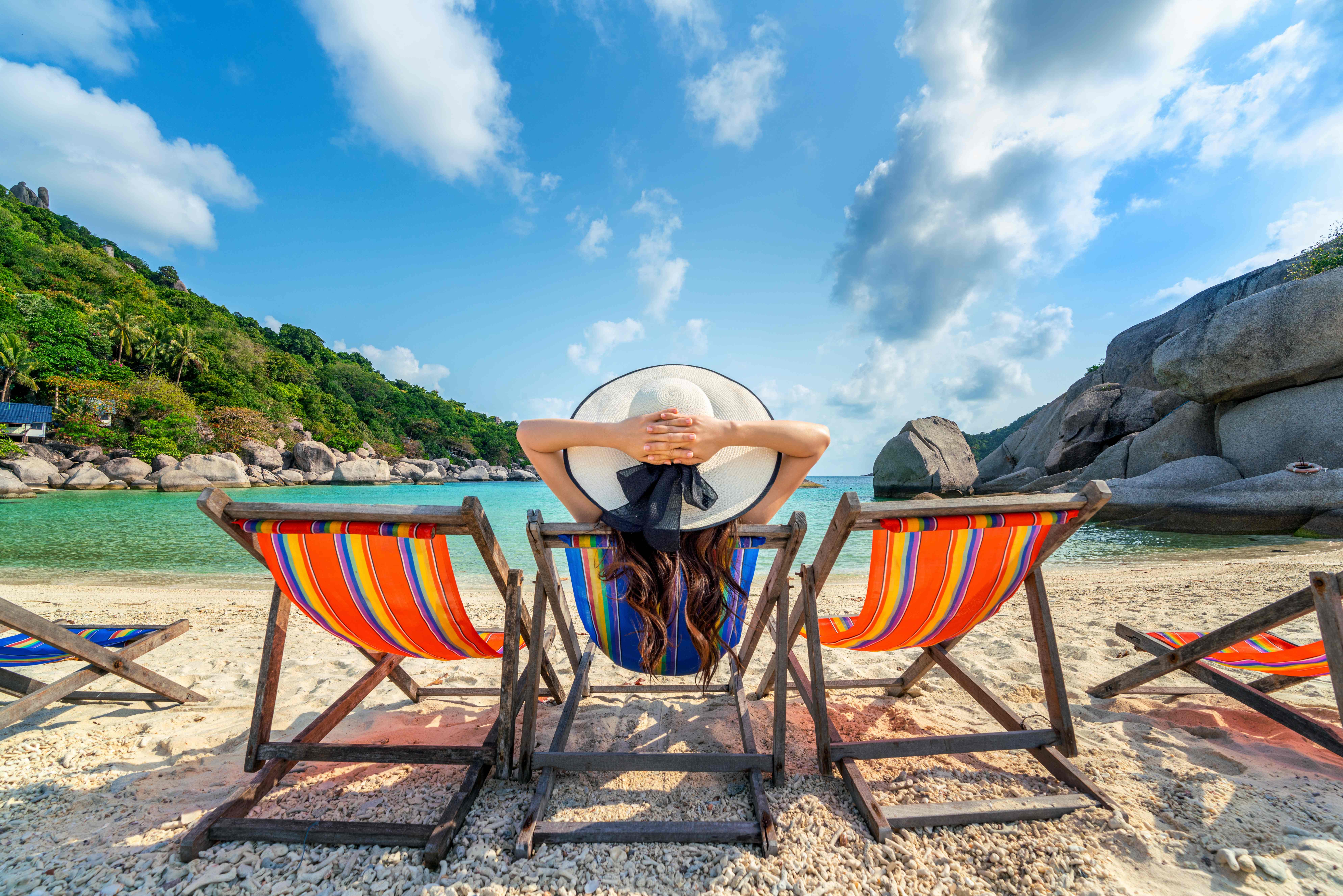 Donna con cappello in spiaggia